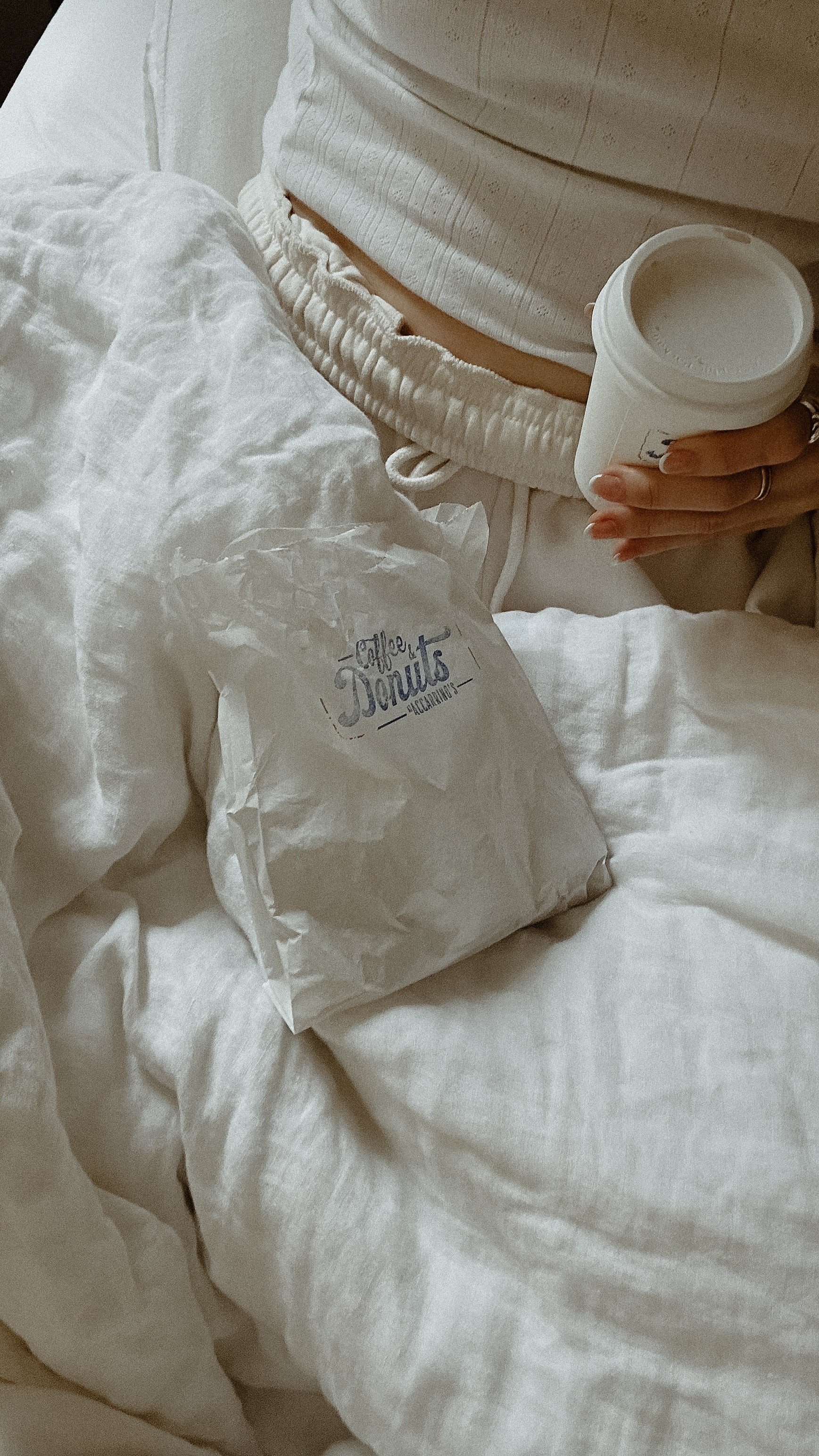 Woman in bed with coffee and pastry