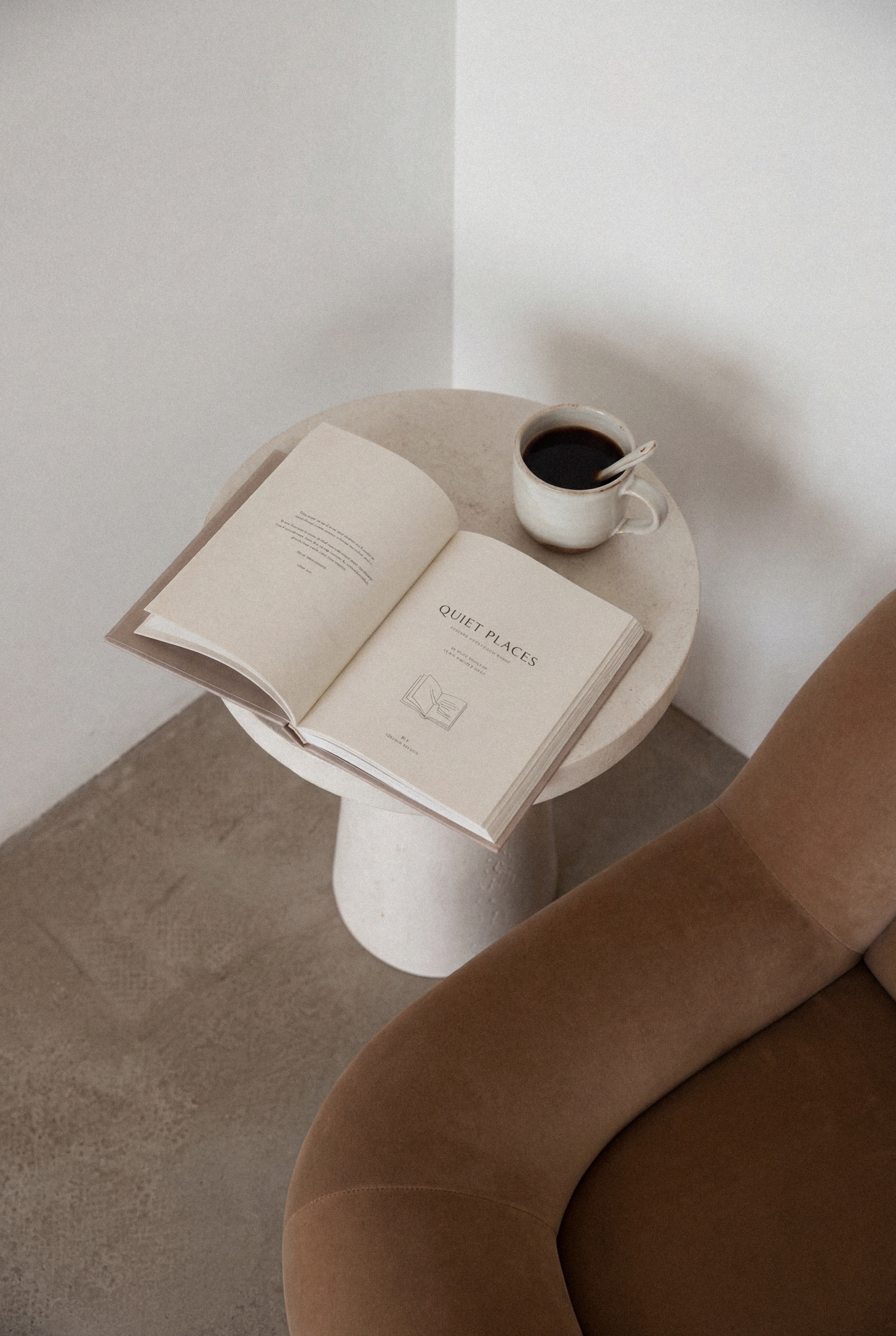 Side table with open book and cup of coffee
