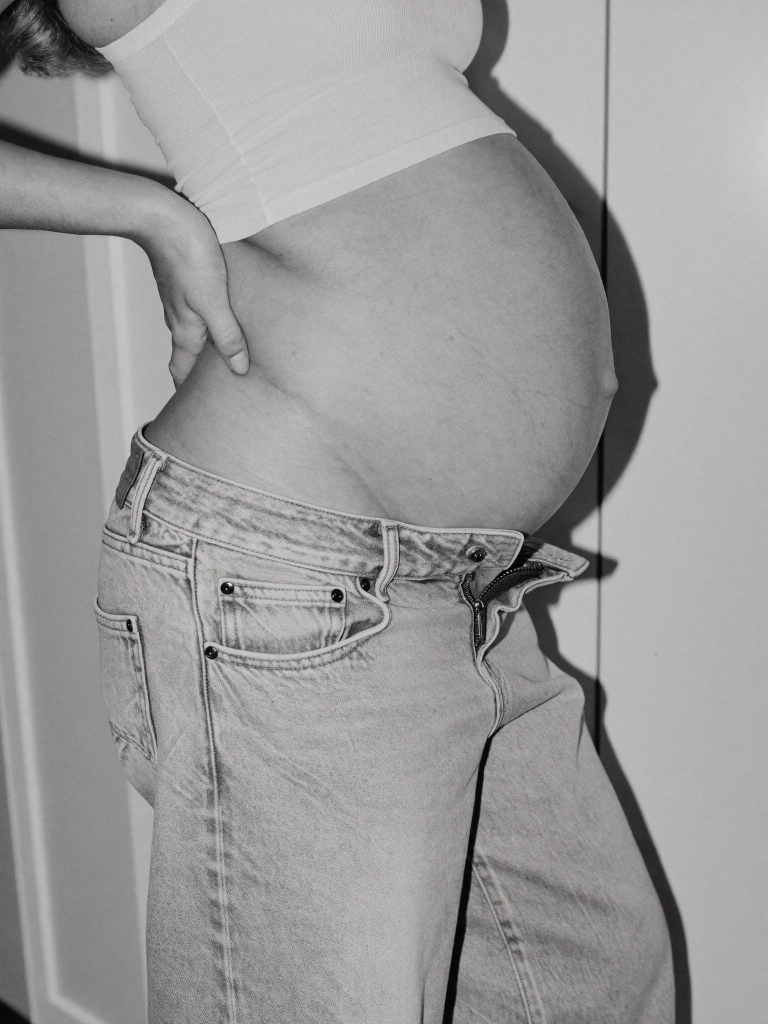 Close up of pregnant bump with jeans unbuttoned