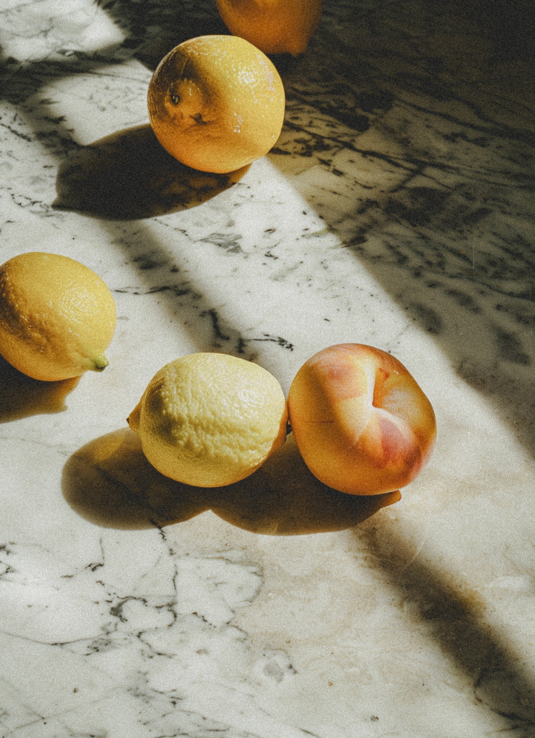 Lemons and peaches on a stone benchtop