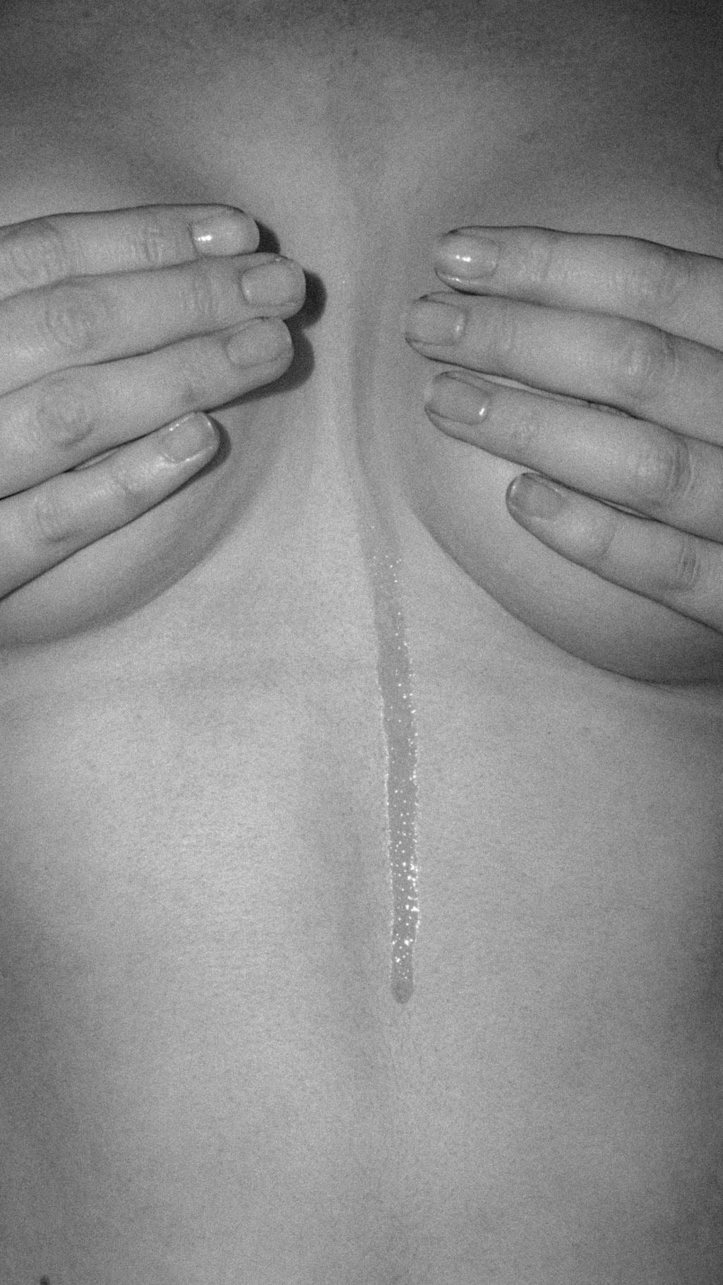 Black and white image of woman holding her breasts